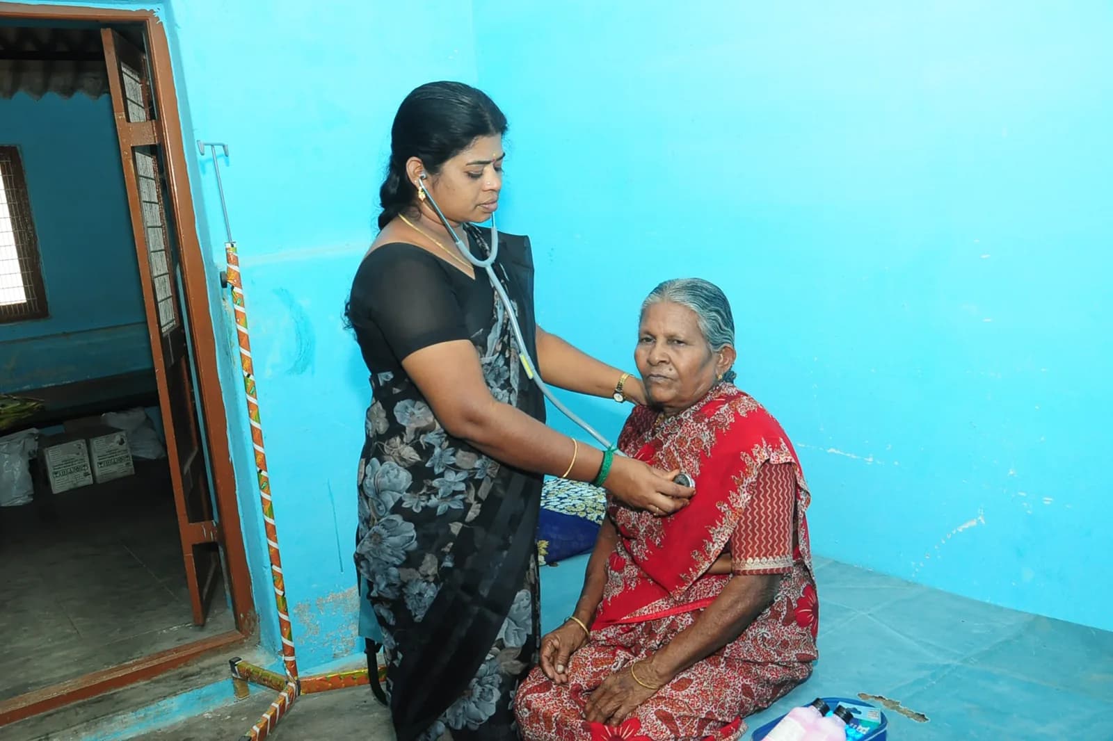 A caregiver with a resident in a red sari